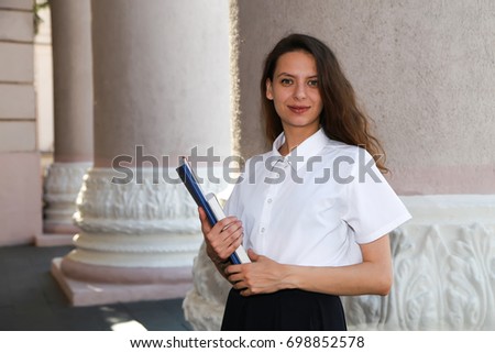 Girl student holding a folder in hands, college student, a school,