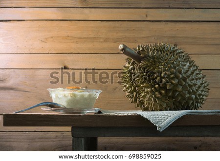 Durian fruit and Durian in coconut milk with sticky rice in cup, Thai dessert on wooden plank / Still life image 


