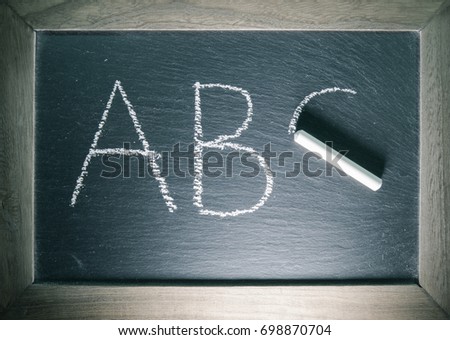 alphabet letters abc written on chalkboard back to school concept with wooden frame