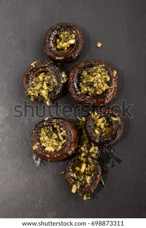 grilled spicy mushroom with garlic and parsley on slate