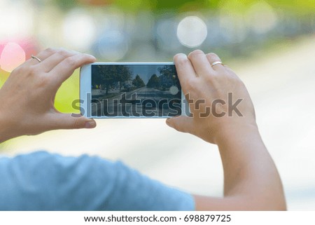 Woman taking photo on a street with smartphone