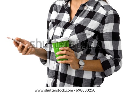 Close up photo of cell phone and a coffee cup in the hands of young woman. Faceless. Isolated on white background.