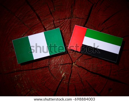 Nigerian flag with United Arab Emirates flag on a tree stump isolated