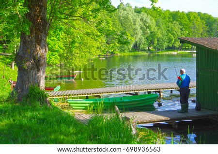 An old man who is fishing in the Lake Galve, Vilnius.