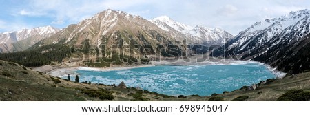 Amazingly blue Big Almaty lake covered with ice Royalty-Free Stock Photo #698945047