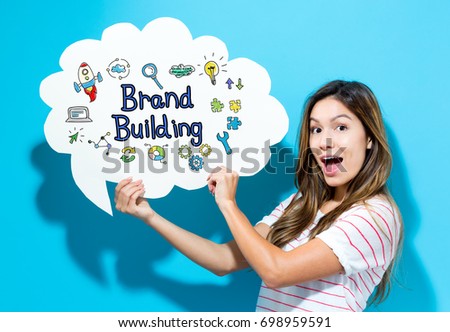 Brand Building text with young woman holding a speech bubble on a blue background