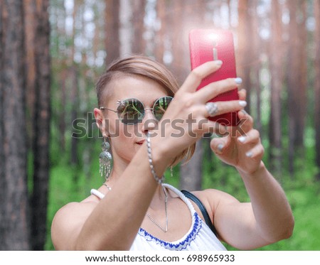 Girl in sunglasses and phone in hands doing selfie