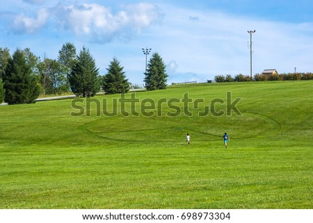 Kids run towards the giant peace sign in the hillside of the Woodstock concert field.