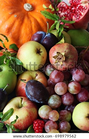 Fruit box with pumpkin , grapes , apples , pear , plums and pomegranate