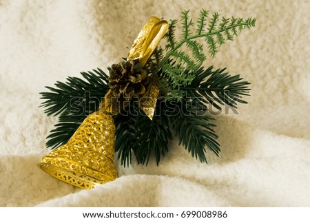 Gold bell with green needles and cone in the white background. Christmas decoration.
