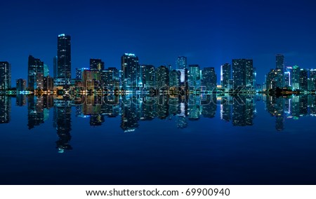 Miami skyline at night - panoramic image with beautiful water reflections