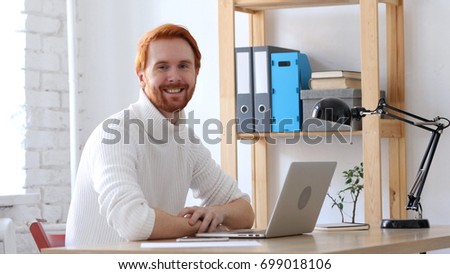 Man with Red Hairs at Work Smiling  toward Camera