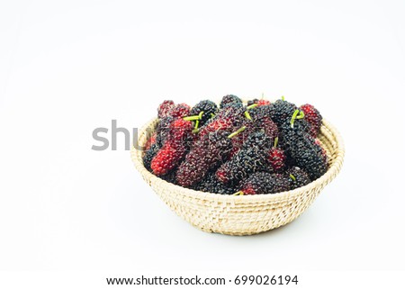 Mulberry in wicker basket isolated on white background.