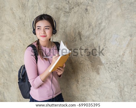 Young Asain female student with notebooks in her hands.A portrait of an Asian college student.education and learning concept
