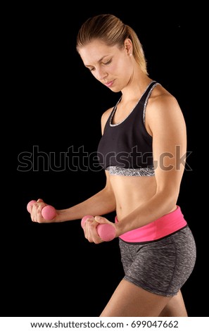 Athletic woman in sports wear lifting weights while doing aerobics.