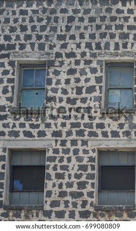 Urban Profile of Four Decaying Windows Against a Lava Brick Building in Old Honolulu Hawaii.