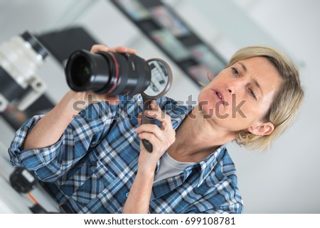 woman checking the lens of her camera
