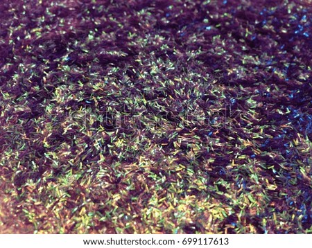 Iridescent violet or purple glitter confetti abstract background concept study (focus, unfocused, light and shadow)