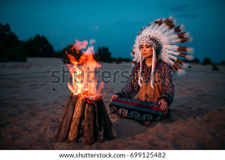 Young American Indian woman against fire