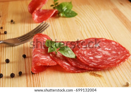 Spain sausage Salchichon Slicing salami Wooden background