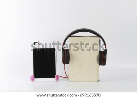 Headphone attached to the book and connected to the digital tablet. Educational concept