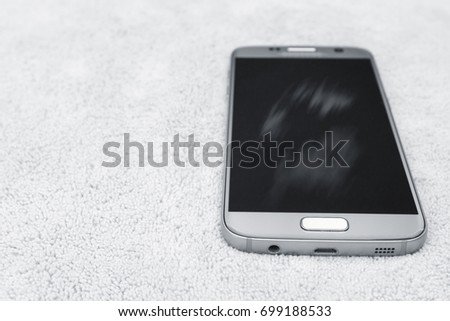 Smartphone cleaning dirty screen with microfiber fabric,black and white picture