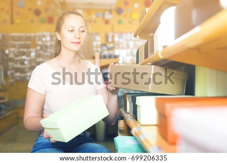 Girl with gift boxes in her hands chooses accessories for gift in store