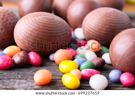  chocolate easter eggs  and sweets on wooden background