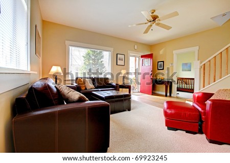 Large yellow living room with leather sofas and red chair