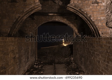 Photo taken from a tunnel capturing the lighthouse with light trails