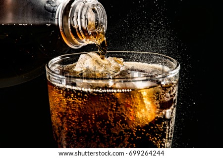poured beverrage into a glass with ice,Cola drink is fizzy Royalty-Free Stock Photo #699264244