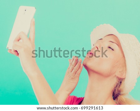 Technology, modern photography, confidence conept. Happy attractive adult blonde woman in sun hat taking picture of herself with smartphone, selfie.