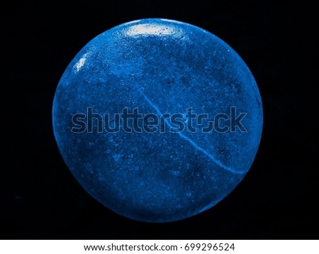 Blue round stone isolated on black background.