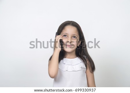 The little girl is talking on the phone