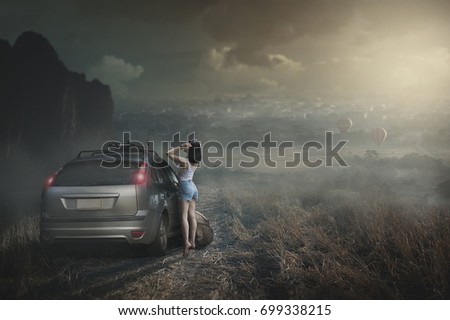 manipulation picture of backpack girl standing beside a car with mountain background