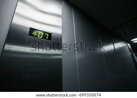 Interior of the elevator inside. View of the panel with the number and steel silver lining.