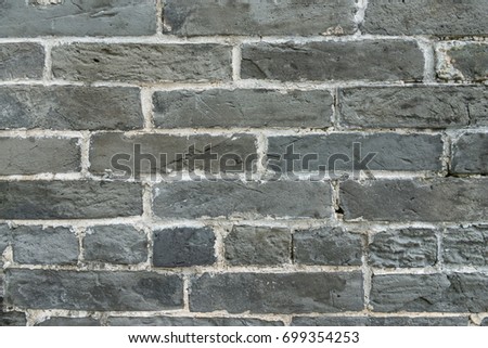 Modern bricks with decorative holes, grey wall background.