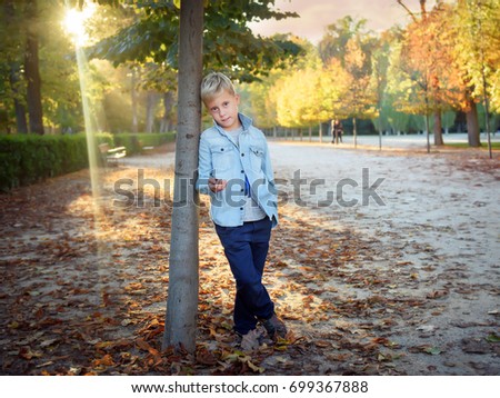 Cute boy on the background of the autumn landscape