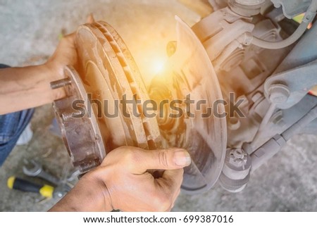The mechanic is assembling parts of the car brake system.Car maintenance.