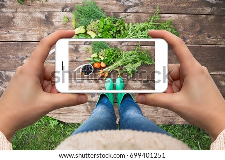 Woman taking picture of vegetables