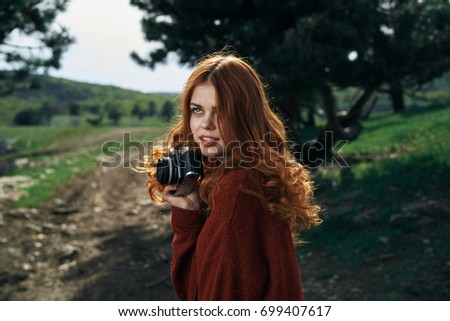 Woman in nature holds the camera takes pictures, travel                               
