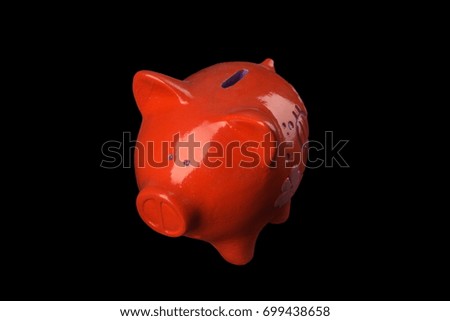 Red piggy with a pattern on his side a statuette of a money box on a black background