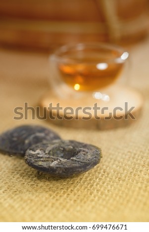 Cup of freshly brewed tea and Beads of Chinese Puer tea