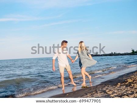 Young beautiful couple having fun on the beach