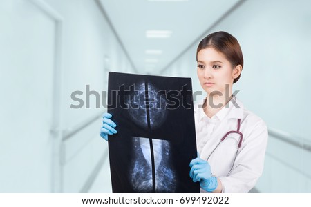 Thoughtful female doctor looking at the Mammogram film image.