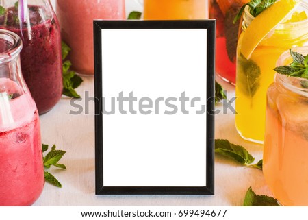Blank picture frame with fresh fruit drinks around. 