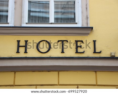 Black Hotel Text Sign on Old Yellow Building