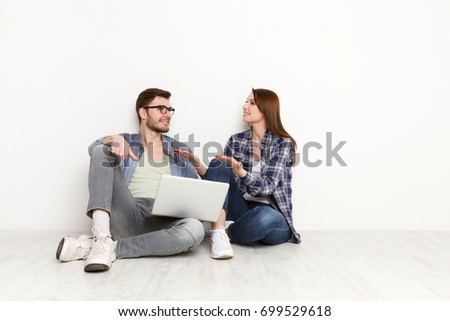 Couple conversation with laptop. Man and woman watching movie on laptop computer abd discuss it, white background, studio shot