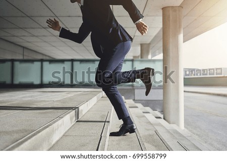 Businessman running up the stairs  Royalty-Free Stock Photo #699558799