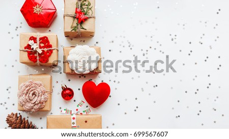 Christmas and New Year background with presents and decorations - red heart, craft paper, handmade crocheted flowers and symbols of holiday. Place for text.